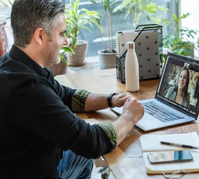 man in a video call with a woman on his laptop