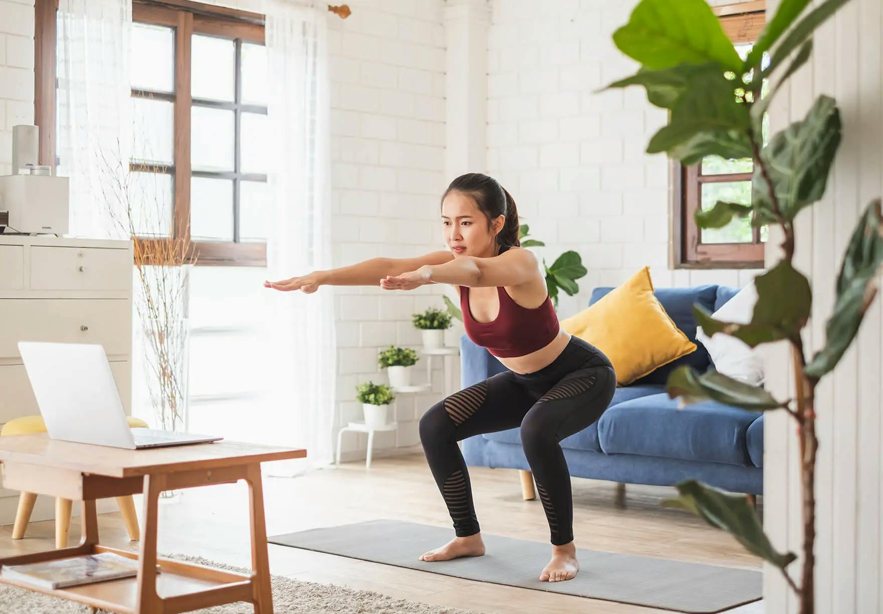 A woman doing yoga in her living room.