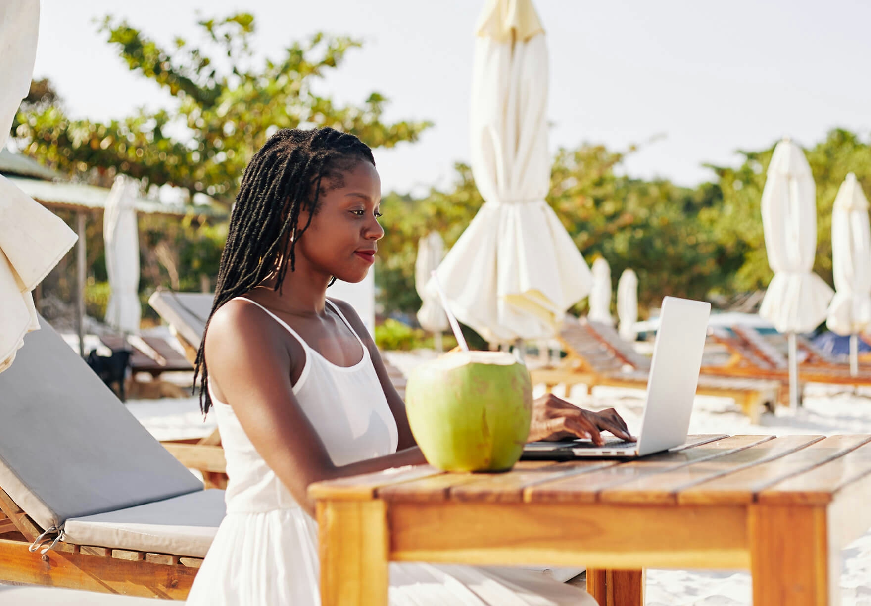 Woman working remotely from a beach destination 