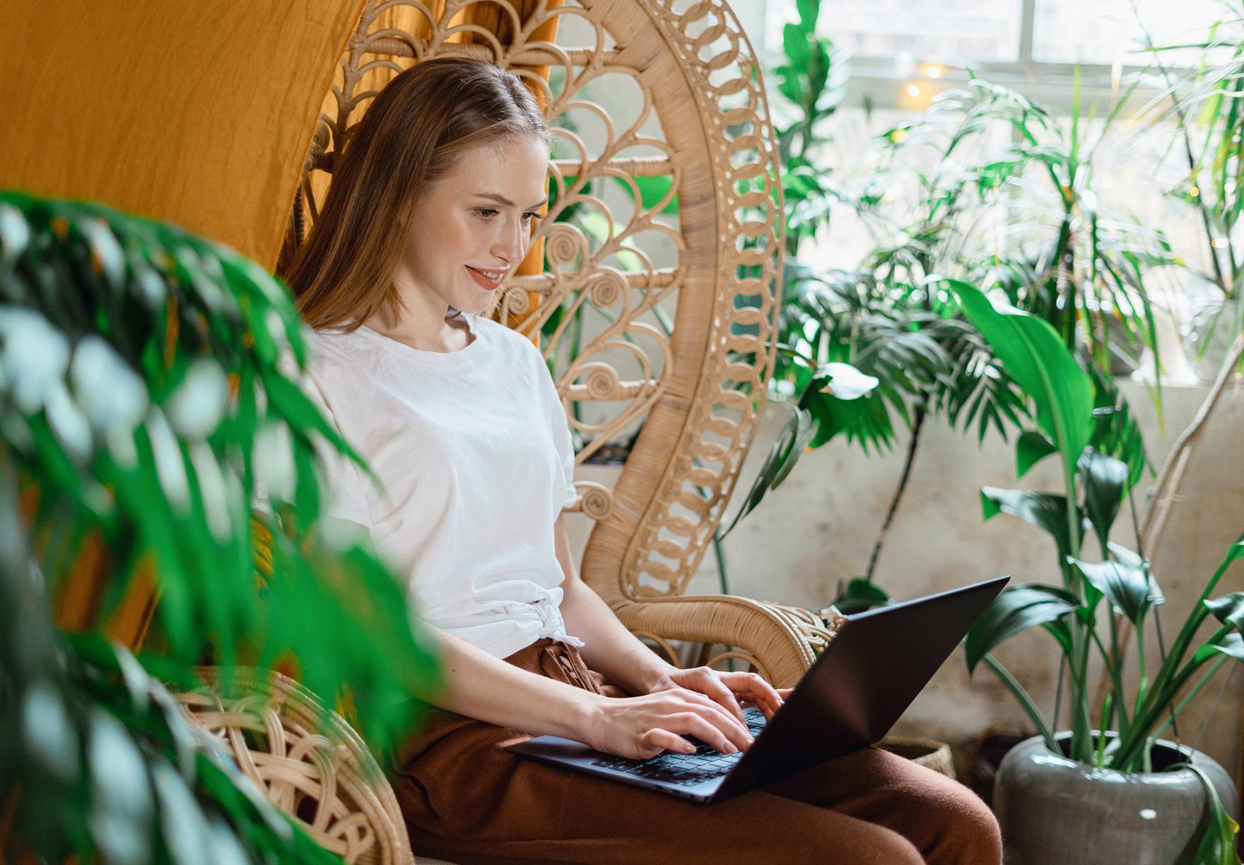 A woman working remotely surrounded by houseplants