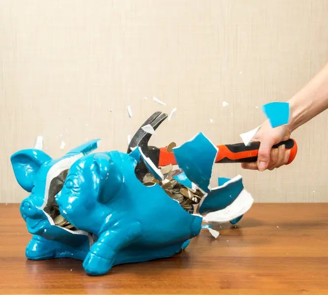 piggy bank being smashed with a hammer