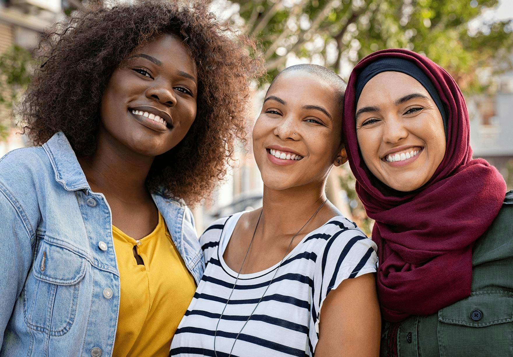 Three women smiling with optimism
